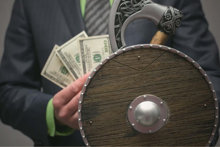 picture of a Viking shield with a man holding some money