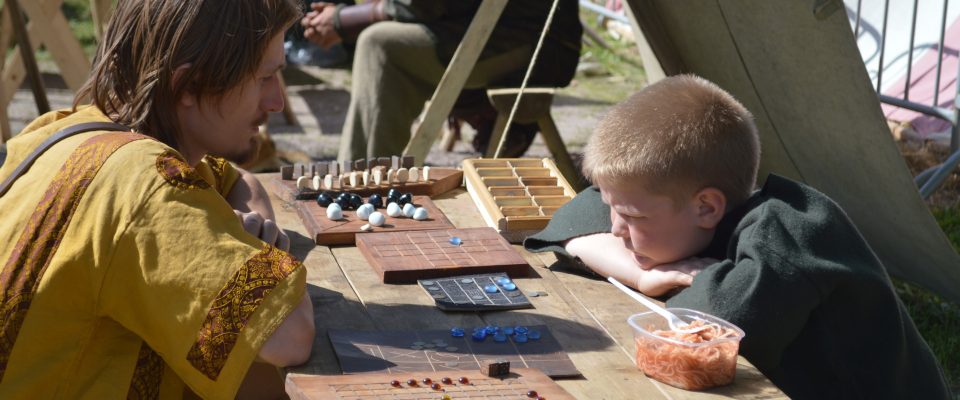 Two opponents playing Viking chess or hnefatafl.