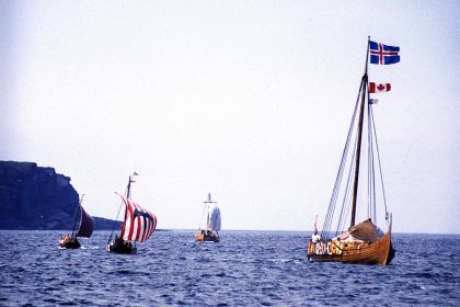Reenactment of the Viking landing at L'Anse aux Meadows, Newfoundland, Canada, 2000. The foremost longship is flying, from top to bottom, the flag of Iceland, the flag of Canada, and the flag of Newfoundland and Labrador.