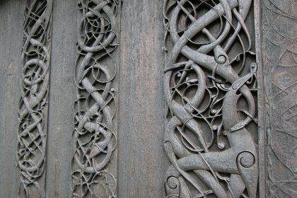 Interlaced serpents and a four-legged beast carved in wood on the north portal of Urnes stave church, Norway