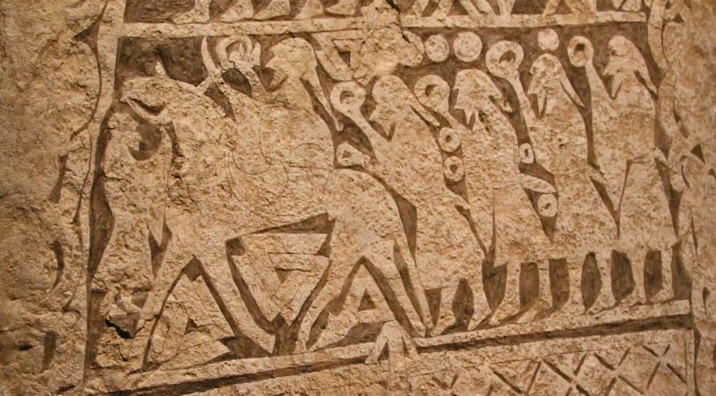 Valknut symbols, three interlocked triangles, carved beside horse and human figures on the Tangelgarda picture stone